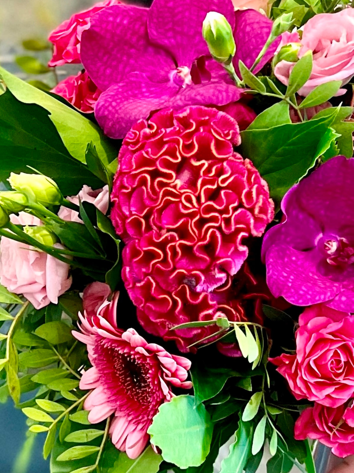 A pretty flower arrangement in shades of pinks in cube vase